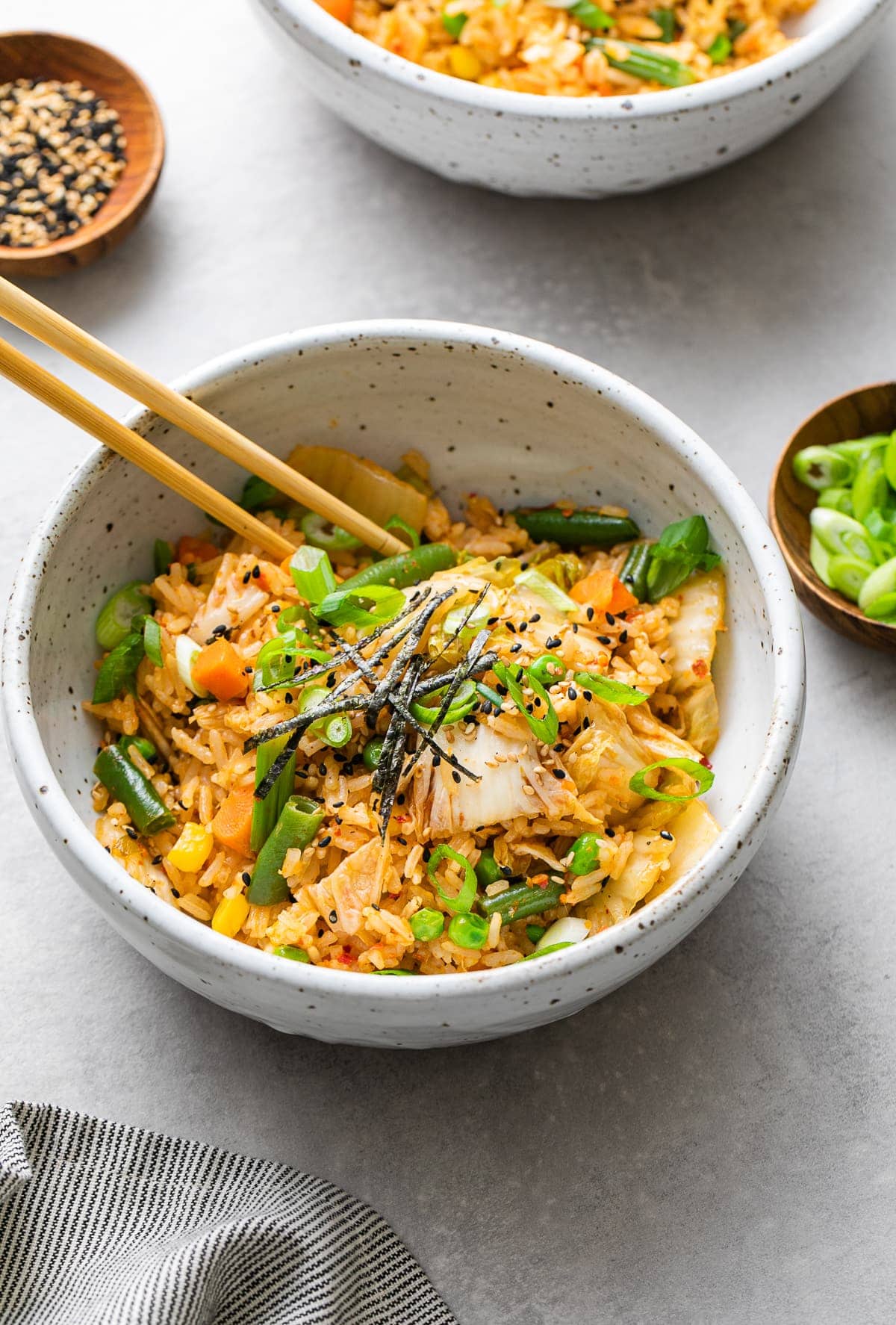 side angle view of bowl with serving of kimchi fried rice with chopsticks.