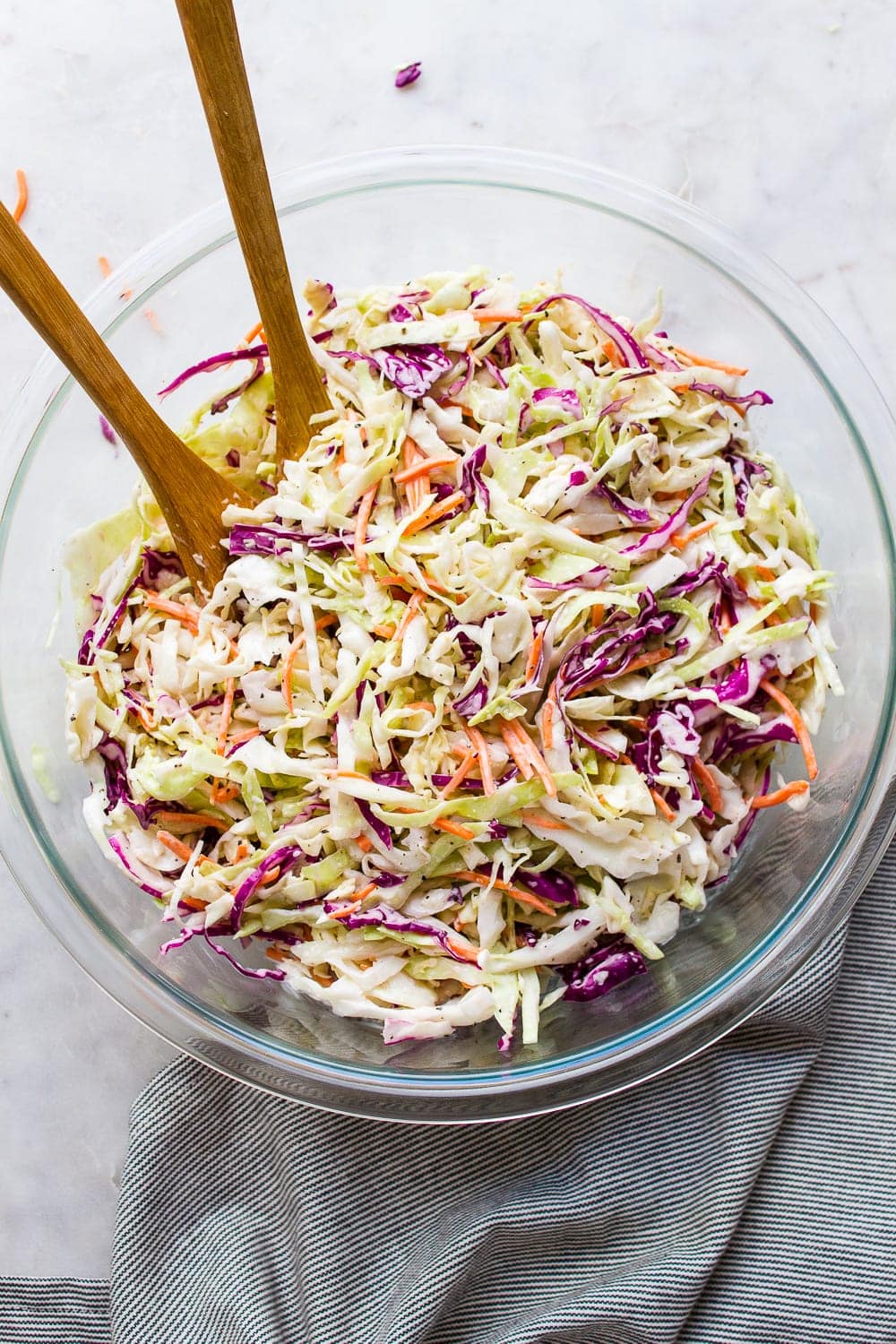 top down view of a glass mixing bowl with freshly made creamy vegan coleslaw.