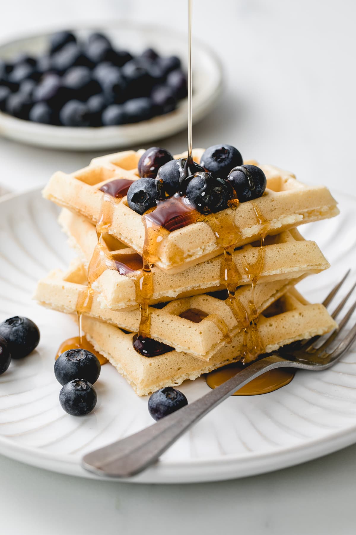 head on view of easy vegan waffles with blueberries and syrup.