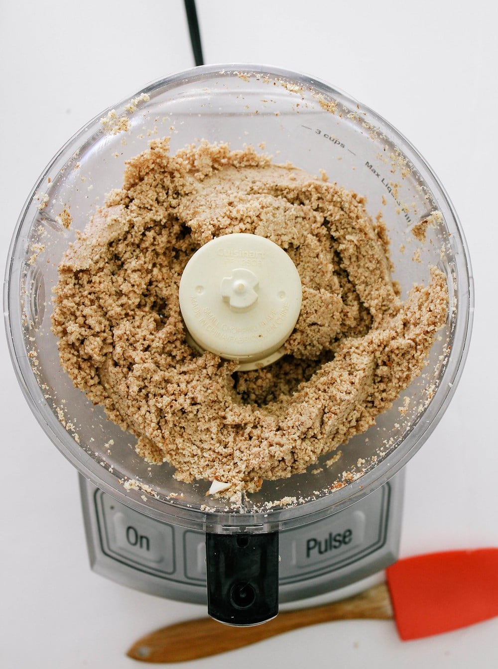 top down view of almond butter processing in food processor for about 5 minutes