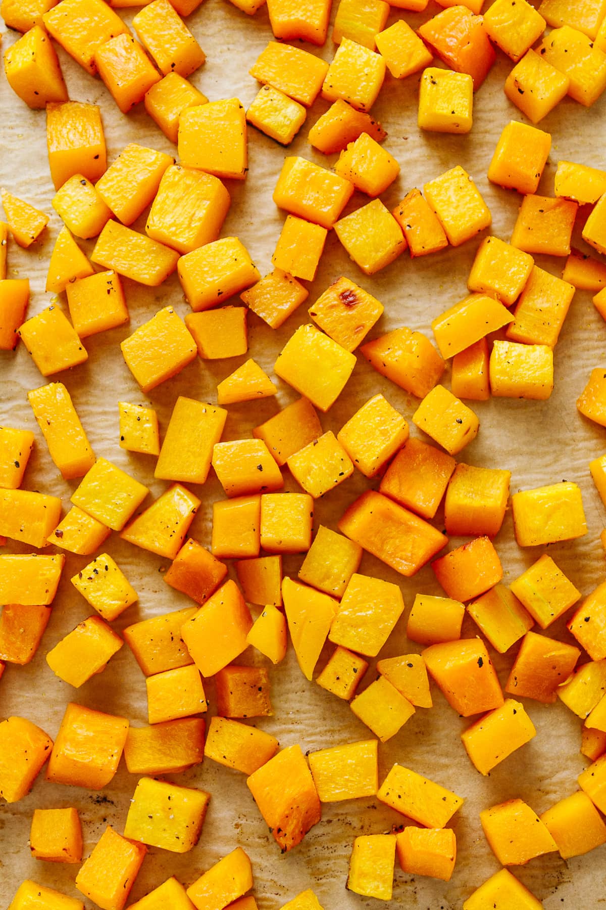 top down view of freshly roasted butternut squash on a rimmed baking sheet.